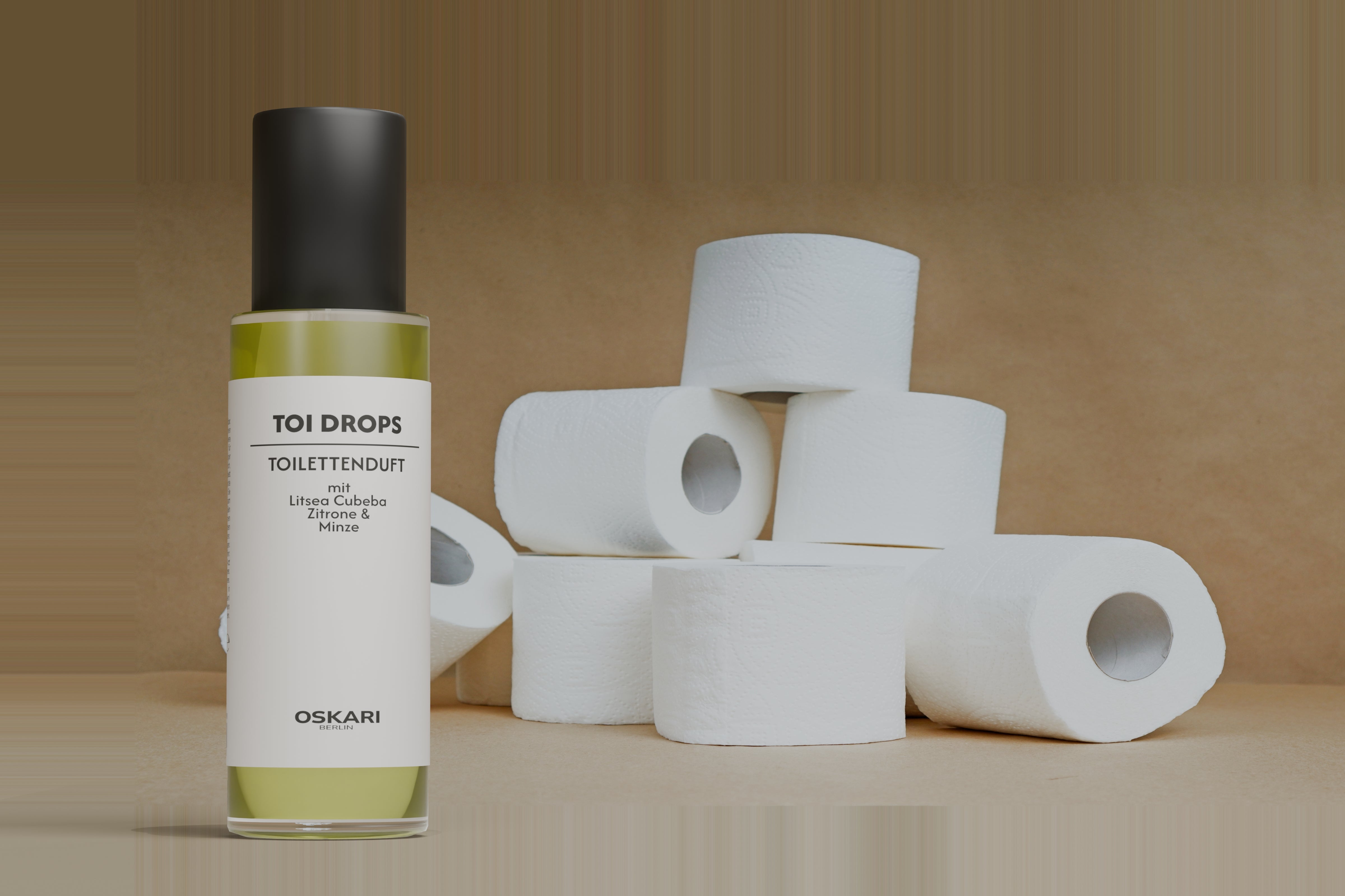 Toi Drops Flakon mit edler schwarzer Kappe stehend neben Toilettenpapierrollen