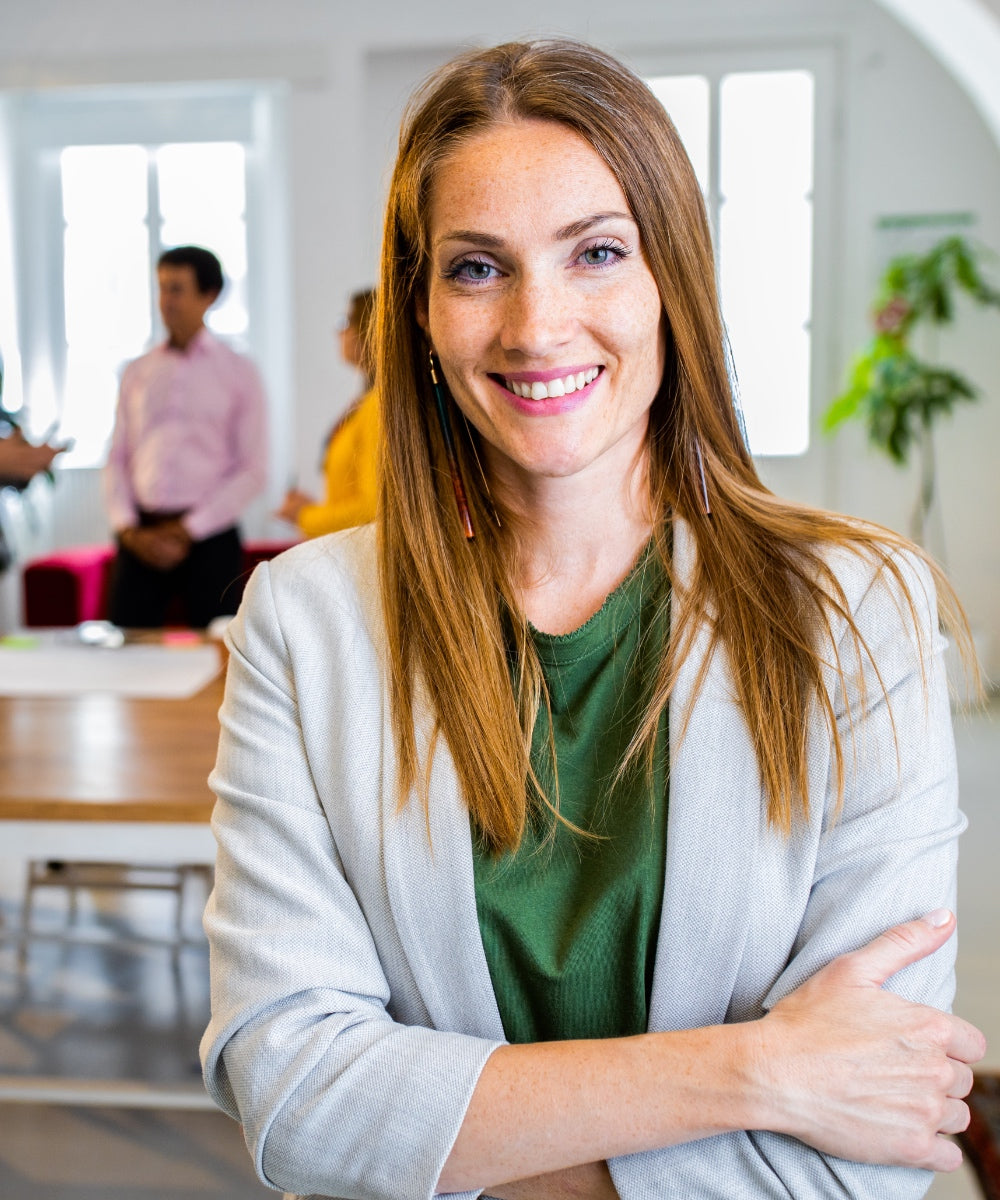 Mittelalte braunhaarige Frau, die selbstbewusst in die Kamera lächelt