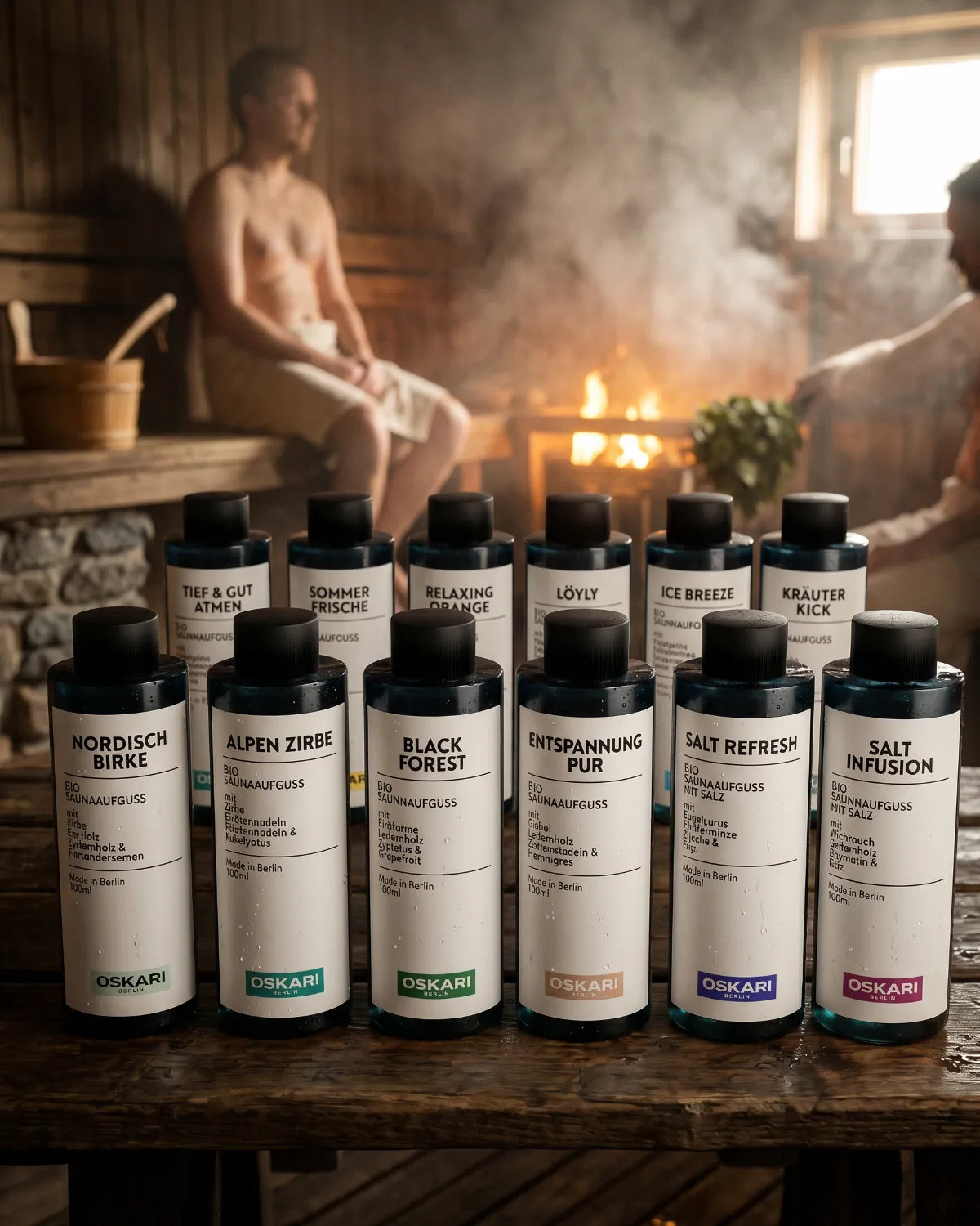 Alle 12 Bio Saunaaufgüsse von Oskari im Bundle Saunameister stehen in einer alten dunklen Sauna vor zwei schwitzenden Männern und dem heißen Saunofen