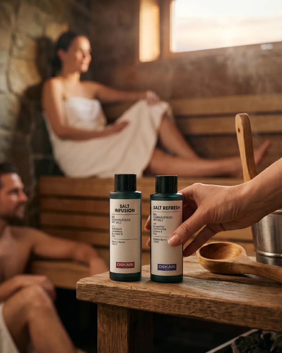 Frau und Mann in gemütlicher Sauna mit den Bio Salzaufgüssen von Oskari