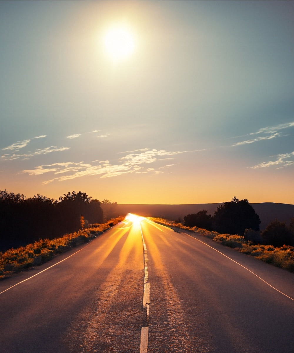 Eine leere Straße bei Sonnenuntergang und hügeliger Landschaft