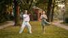 Ein junges Paar absolviet Tai-chi und Yogaübungen in einem Berliner Park bei schönem Wetter