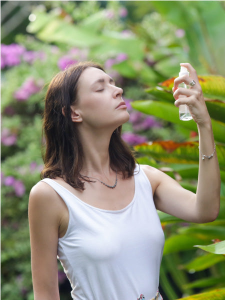 Eine Frau duftet entspannt an einem Oskari Bio Raumspray