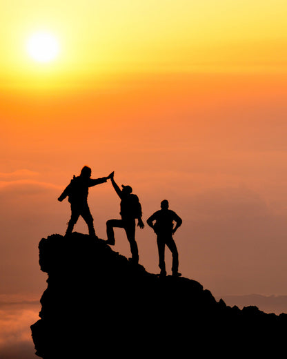 Eine Gruppe Wanderer hat den Gipfel eines in der Abendsonne liegenden erreicht