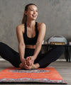 Junge Frau in Yogakleidung im Schneidersitz