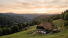 Ein traditioneller Bauernhof im Schwarzwald umgeben won Wald und Hügeln