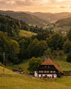 Ein traditioneller Bauernhof im Schwarzwald umgeben won Wald und Hügeln