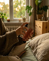 Das Bio Kissenspray Bedtime Blend von Oskari wird von einer weiblichen Hand auf ein Kopfkissen gesprüht