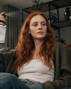 Chill Zone Bio Raumspray wird von einer jungen Frau auf ihrer Couch verwendet