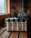 Das Bio Saunaaufguss bundle Classic Collection von Oskari vor einer Sauna stehend