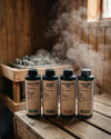 Das Oskari Bio Saunaaufguss Bundle Classic Collection in einer dampfgefüllten Sauna mit den Aufgüssen Alpen Zirbe, Black Forest, Entspannung Pur und Kräuter Kick