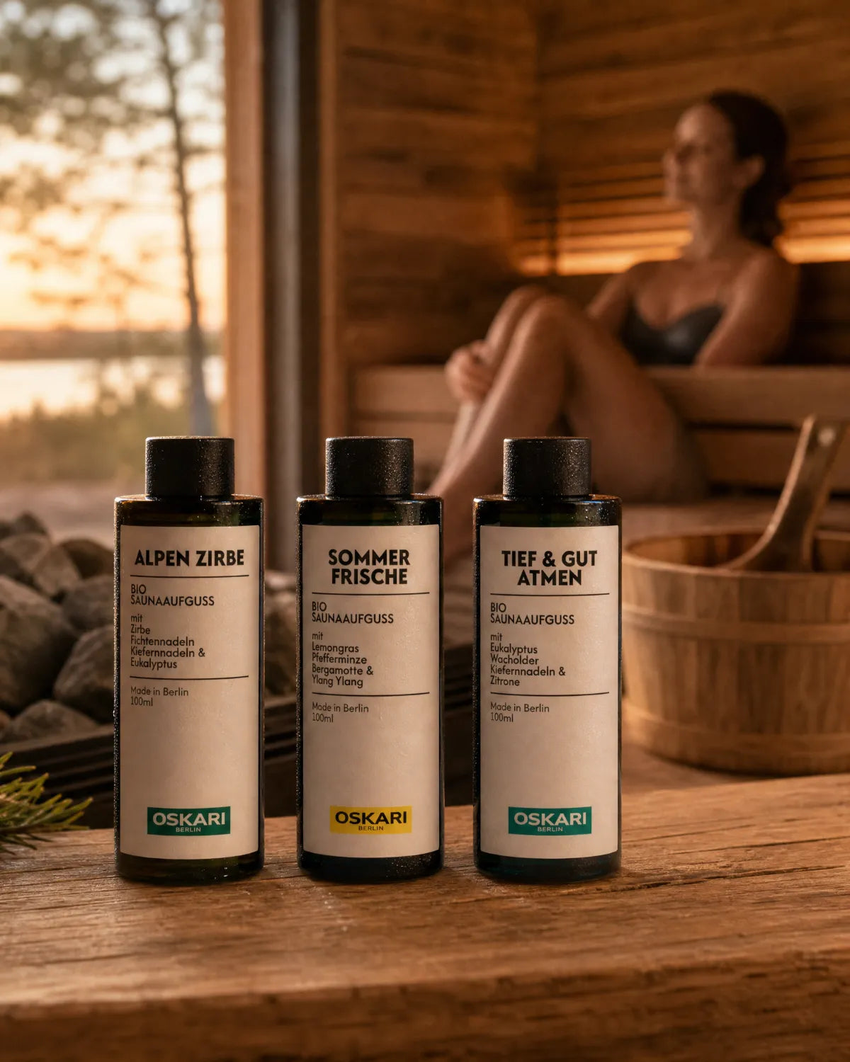 Die drei Bio Saunaaufgüsse Alpen Zirbe, Sommerfrische und Tief & Gut Atmen in einer Sauna mit einer jungen Frau im Hintergrund