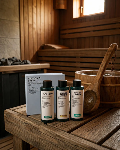 Das Bio Saunaaufguss Set Edition 3 Fresh neben einem Holzeimer in einer Sauna
