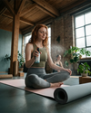 Eine junge rothaarige Frau besprüht ihre Yogamatte mit dem Bio Yogamattenspray von Oskari